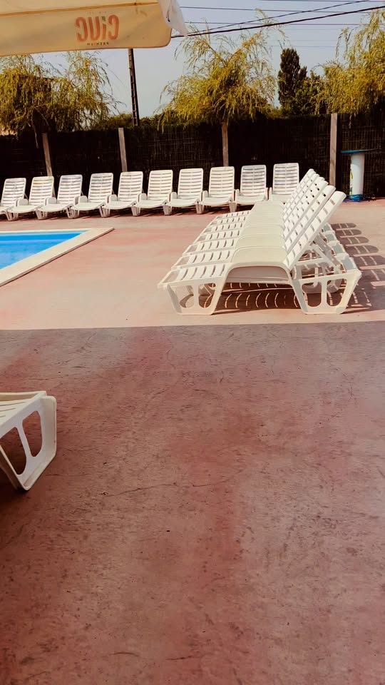 Șezlonguri lângă piscină